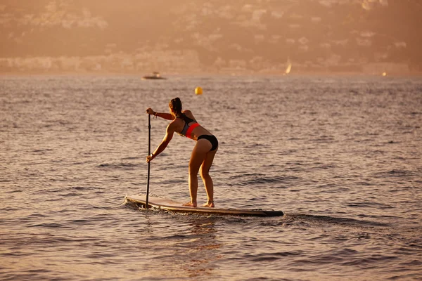 Stand Surf kız raket ile sup. — Stok fotoğraf