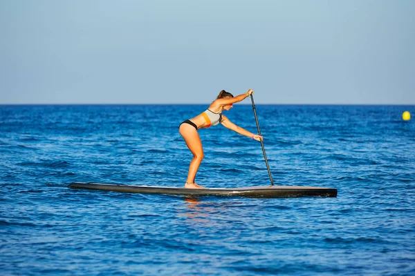 Stand op Surf meisje sup met peddel — Stockfoto