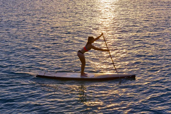 Stand op Surf meisje sup met peddel — Stockfoto