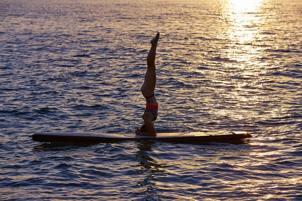 Yoga girl over SUP Stand up Surf board — Stock Photo, Image
