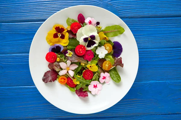 Eetbare bloemen salade in een bord Stockfoto