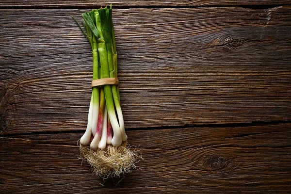 Groene knoflook bos op een houten achtergrond — Stockfoto