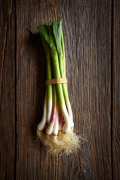 Groene knoflook bos op een houten achtergrond — Stockfoto