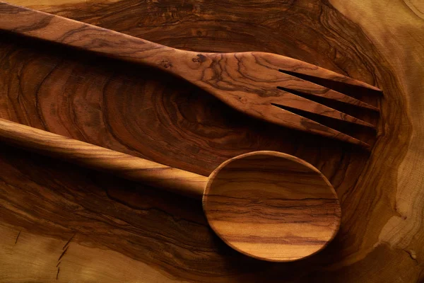 Cuchara de madera de olivo y tenedor en la tabla de cortar —  Fotos de Stock