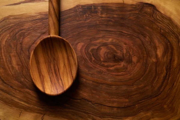 Colher de madeira de azeitona na placa de corte de madeira — Fotografia de Stock