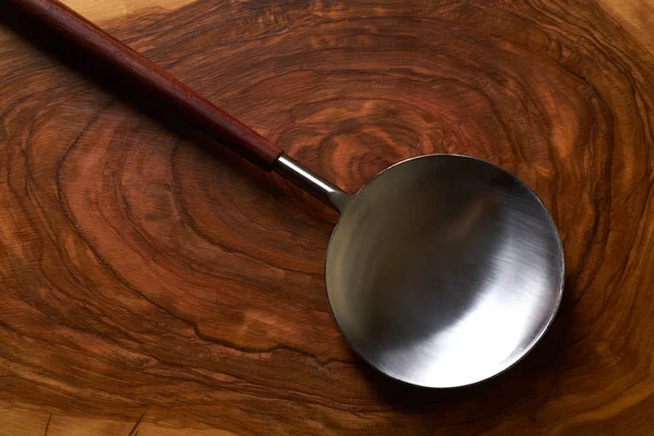 Moderner Löffelspachtel aus Edelstahl auf Holz — Stockfoto