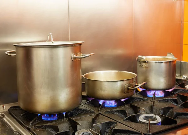 Restaurant pro kitchen with steel pans in fire — Stock Photo, Image