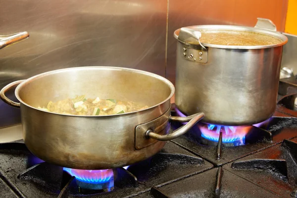 Restaurant pro kitchen with steel pans in fire — Stock Photo, Image