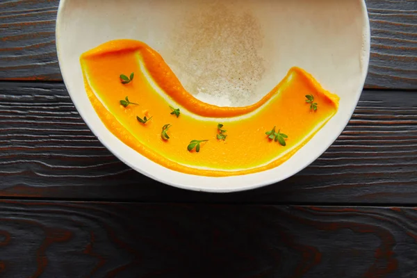 creamy carrot cream painted on white bowl