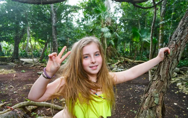 Kaukasische meisje teken van de overwinning te spelen in de jungle — Stockfoto