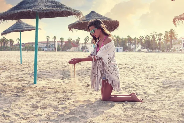 Adolescent fille sur l 'plage jouer avec sable — Photo