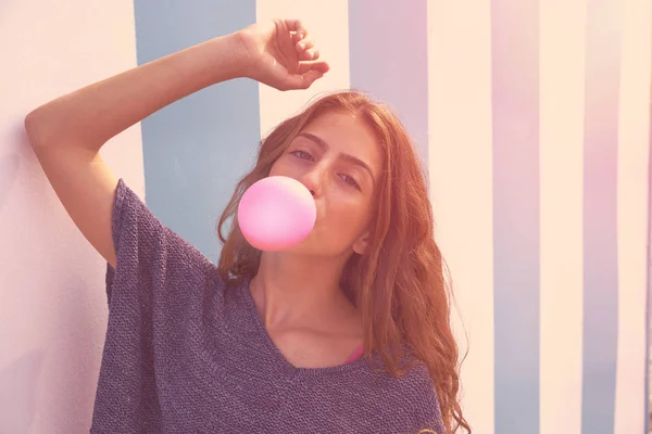 Brünette teen girl bubble gum in blue stripes wall — Stockfoto