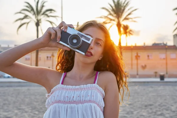 Teen girl with retro photo camera at sunset — Stock Photo, Image