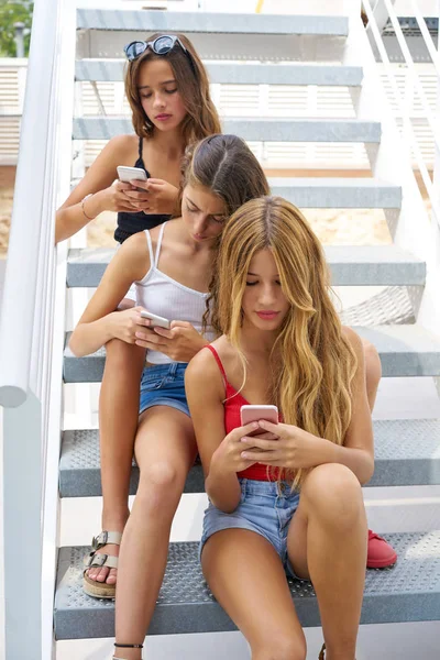 Teenager beste Freundinnen Mädchen in einer Reihe mit Smartphone — Stockfoto