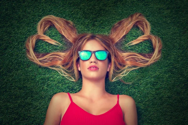 Blond tonåring flicka med hår hjärtat former liggande — Stockfoto