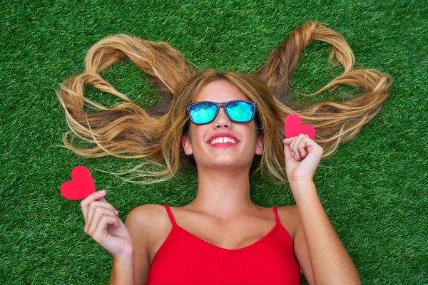 Blond teen girl with hair heart shapes lying — Stock Photo, Image