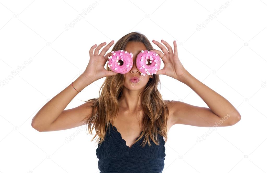 Teen girl holding donuts goggles on her eyes