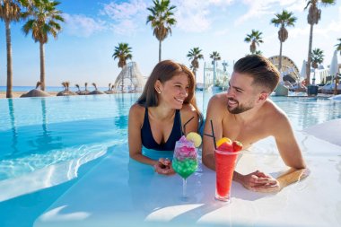 Sonsuzluk havuzu kokteyller üzerinde genç Çift