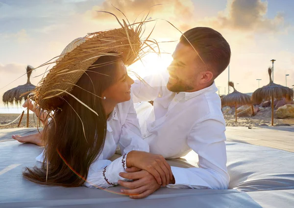 Coppia giovane sulla spiaggia lounge tramonto — Foto Stock