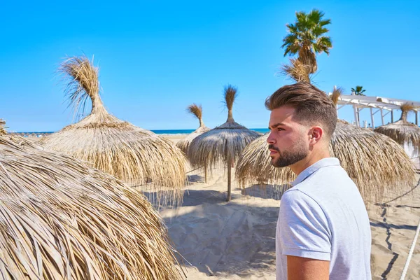 パラソルとビーチの若いひげ男 — ストック写真