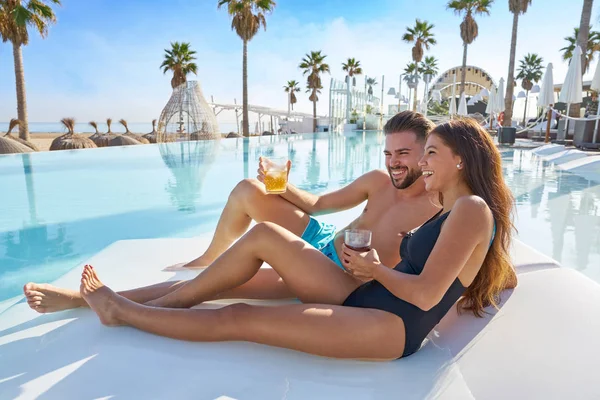 Young couple on pool hammock at beach resort — Stock Photo, Image