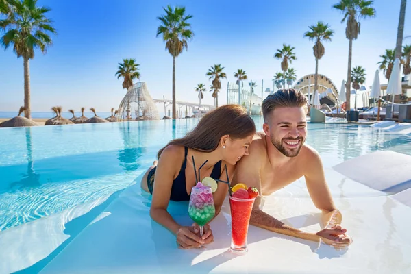 Jeune couple sur des cocktails piscine à débordement — Photo
