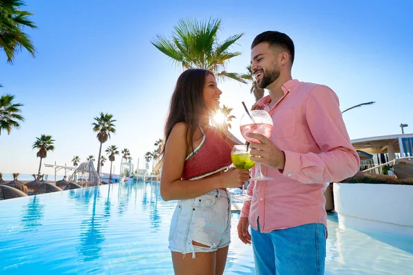 Jovem casal bebendo coquetel no resort piscina — Fotografia de Stock