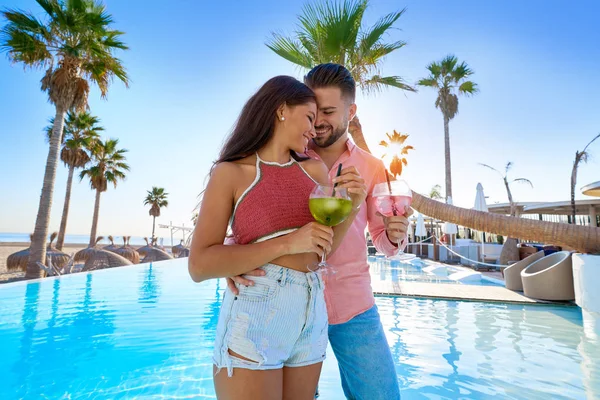 Jovem casal bebendo coquetel no resort piscina — Fotografia de Stock