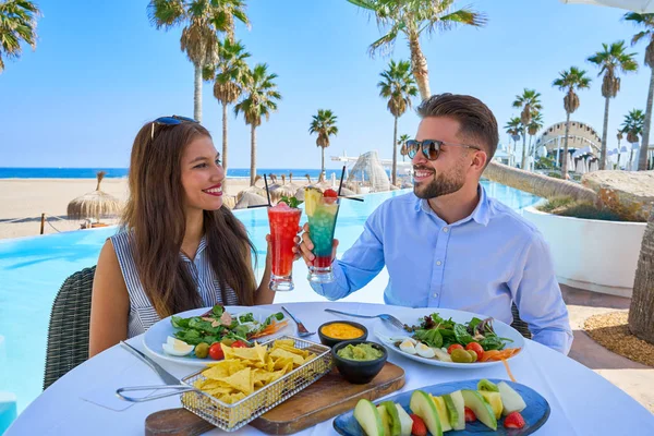 Unga par med drinkar i poolrestaurangen — Stockfoto