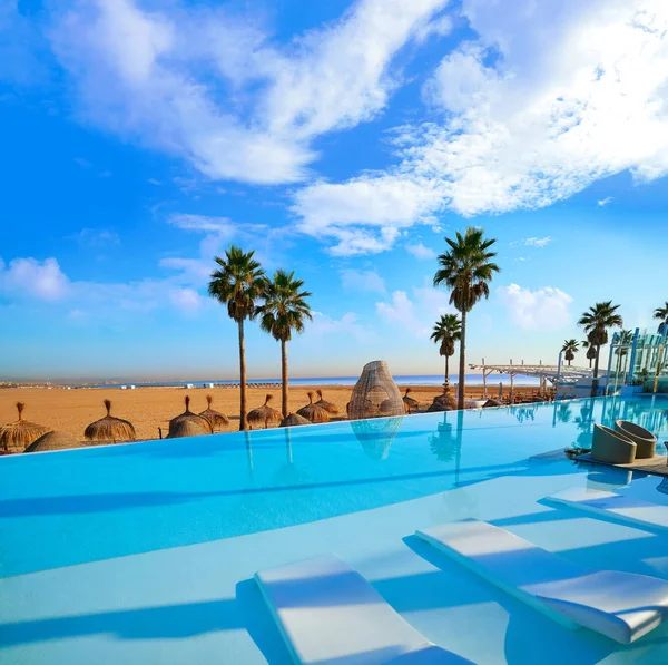 Resort infinity pool in a beach with palm trees — Stock Photo, Image