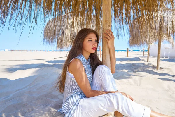 Jovem mulher em uma praia sob guarda-sol — Fotografia de Stock