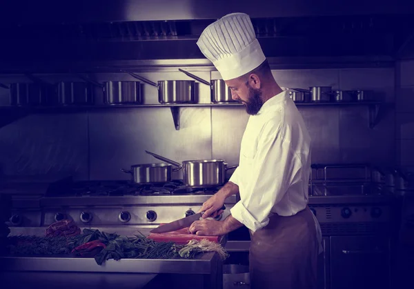 Kocken styckning av kött i restaurangkök — Stockfoto