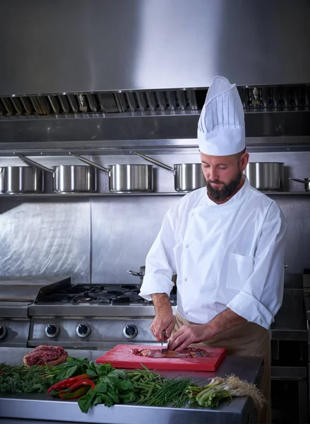Kocken styckning av kött i restaurangkök — Stockfoto