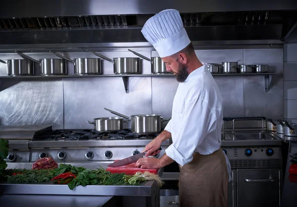 Chef-kok snijden vlees in restaurant keuken — Stockfoto