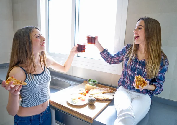 Best friend girls eating pizza in the kitchen — Stock Photo, Image