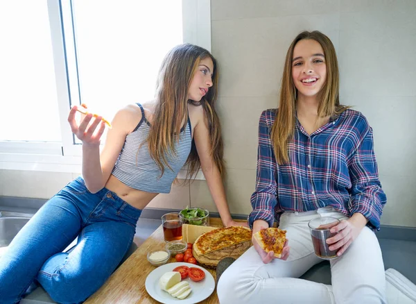 Кращі подруги дівчата їдять піцу на кухні — стокове фото