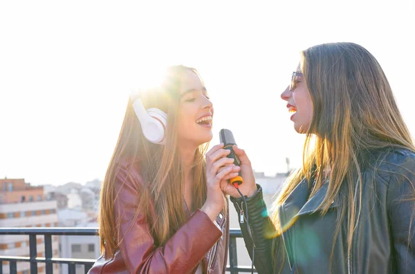Přátel kapely firls zpívá karaoke na střešní terasu — Stock fotografie