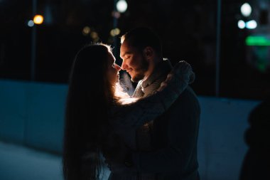 Bir Noel Pazar geceleri mutlu çekici çift. Güzel bokeh ışıklar arka plan.