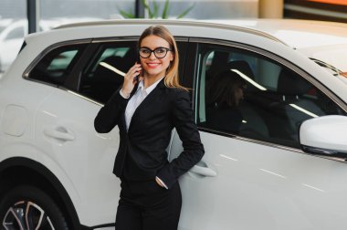 Güzel genç bir kadın galeri salonundan bir araba alıyor..