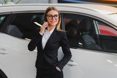 Güzel genç bir kadın galeri salonundan bir araba alıyor..