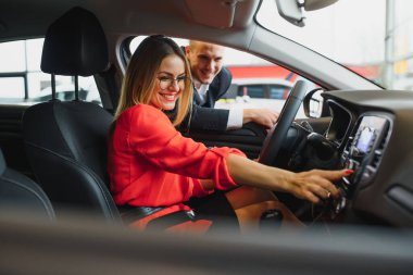 Hintli satıcı potansiyel müşteriye araba özelliklerini açıklıyor