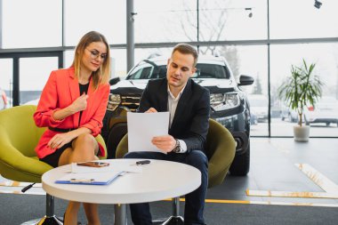 İş kadını araba galerisinden araba alır. Mutlu iş insanları kavramı