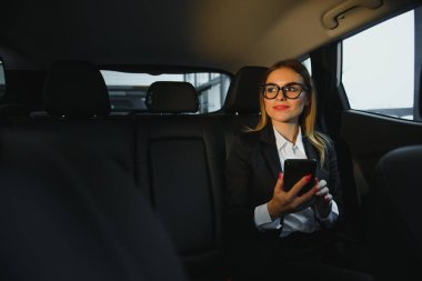 İlginç bir bilgi. Zeki iş kadını, siyah iç mekanı olan lüks arabanın arka koltuğunda oturur..