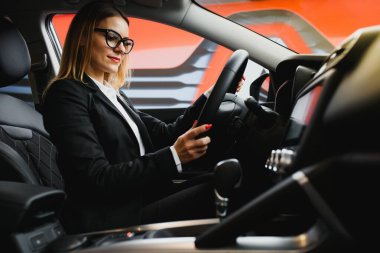 İşe arabasıyla giden genç bir iş kadını. Başarılı iş konsepti. İş kadını sürücüsü