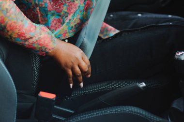 Koyu kahverengi tenli Afrikalı kadın araba kazası güvenlik konsepti için emniyet kemeri takıyor.