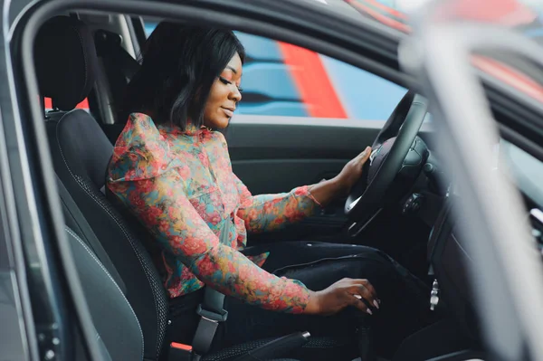 cheerful african female driver inside a car