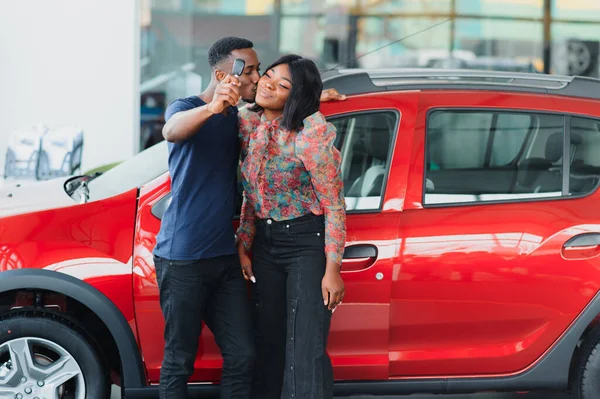 Genç Afrikalı çift galeriden yeni araba alıyor.