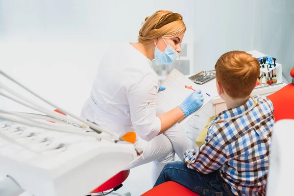 Οδοντίατρος Μάσκα Κοκκινομάλλα Οδοντίατρος Φορώντας Μάσκα Εξετάζοντας Χαριτωμένο Αγόρι — Φωτογραφία Αρχείου