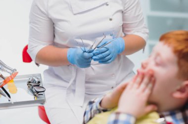 Dişçi muayenehanesinde kadın dişçi ve çocuk