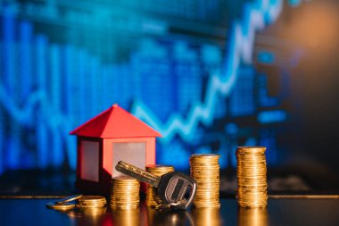 Bir yığın bozuk para ev olarak gölge düşürüyor, tasarruf kavramı.